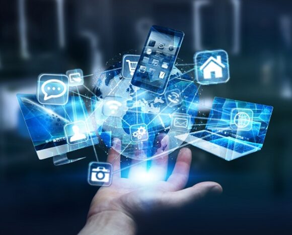 Eine Hand hält einen leuchtenden Globus mit digitalen Symbolen wie Smartphone, Haus, Umschlag und Sprechblase vor einem verschwommenen Bürohintergrund. Diese Bilder unterstreichen globale Vernetzung und Technologie und spiegeln den Geist des Safer Internet Day wider, der sichere Online-Interaktionen fördert.