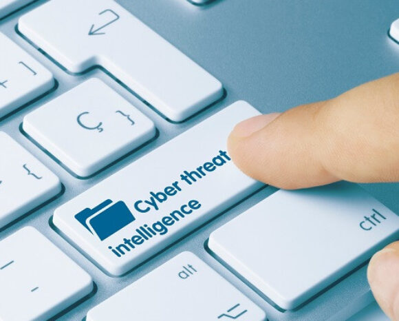 Ein Finger drückt eine weiße Computertastaturtaste mit der Aufschrift „Cyber Threat Intelligence“ neben einem Ordnersymbol und unterstreicht damit das Bewusstsein für Cybersicherheit im Zeitalter von Cyberangriffen. Die überwiegend weiße Tastatur unterstreicht die Bedeutung proaktiver digitaler Verteidigung.