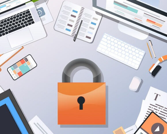 Draufsicht auf einen Schreibtisch mit einem großen orangefarbenen Schloss in der Mitte, umgeben von Laptops, einem Smartphone, Papieren, einer Tastatur und einer Tasse. Die Szene weckt Erinnerungen an digitale Sicherheit und Datenschutz.