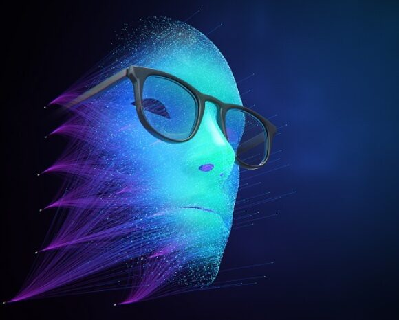 Ein digitales Gesicht mit holografischem Aussehen und Brille, das an Deepfakes erinnert. Das Gesicht besteht aus blauen und violetten Datenströmen, die vor einem dunkelblauen Hintergrund ein futuristisches und abstraktes Aussehen erzeugen.