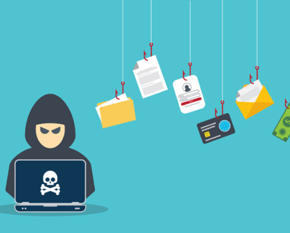 Eine vermummte Gestalt lauert bedrohlich an einem Laptop mit Totenkopfsymbol. Darüber baumeln Gegenstände wie ein Ordner, ein Ausweis und ein Dollarschein an Haken und stellen Phishing-Angriffe dar. Diese Szene veranschaulicht Social-Engineering-Techniken vor hellblauem Hintergrund.