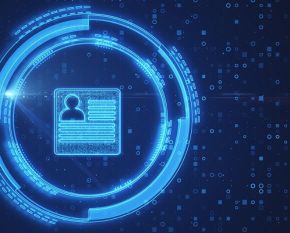 Eine futuristische digitale Benutzeroberfläche mit einem leuchtend blauen Kreis umgibt ein Symbol, das einem Benutzerprofil ähnelt und Identitätsmanagement verkörpert. Der dunkelblaue Hintergrund ist mit kleinen digitalen Elementen verziert, die einen Hightech-Look im Cyber-Stil erzeugen.