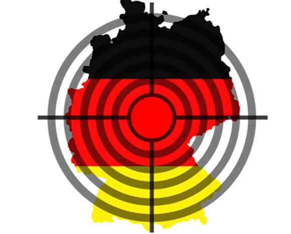 Eine Deutschlandkarte ist mit den Farben der Nationalflagge überlagert: oben Schwarz, in der Mitte Rot und unten Gelb. In der Mitte der Karte befindet sich ein Zielsymbol mit konzentrischen Kreisen und einem scharfen Fadenkreuz, das auf Cyberkriminalität hinweist.