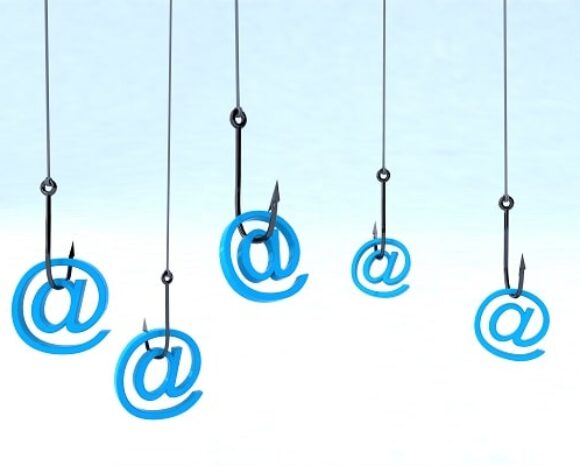 Fünf blaue „@“-Symbole baumeln an Angelhaken vor einem hellblau-weißen Hintergrund und symbolisieren perfekt Internet-Phishing oder digitalen Betrug.