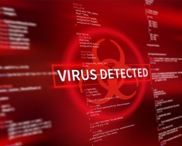 Verschwommener Code auf rotem Hintergrund mit einem auffälligen Biogefährdungssymbol. Der darüberliegende Text lautet „VIRUS DETECTED“ in Weiß und Rot und weist auf eine Computerviruswarnung hin, die mit möglichen Ransomware-Zahlungen in Verbindung steht.