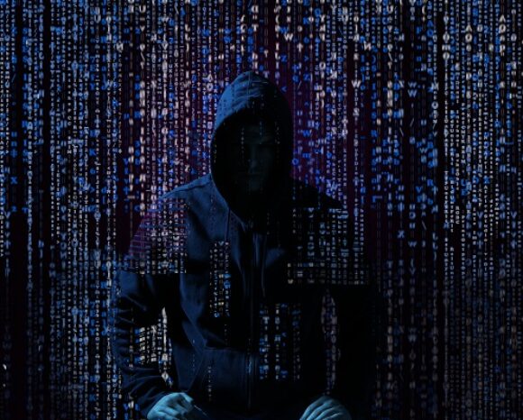 Eine Person mit Kapuzenjacke sitzt inmitten eines digitalen Code-Regens, der an ein Semikron-Hacker-Thema erinnert. Die Szene hat eine dunkle, geheimnisvolle Atmosphäre, in der Zahlen und Buchstaben wie in einer Matrix herabstürzen.