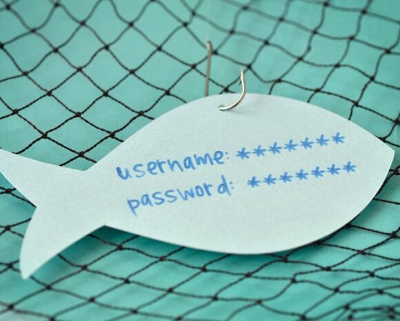 Ein Papierfisch, der an einem Angelhaken und einem Netz baumelt, enthüllt auf subtile Weise den Text: „Benutzername:“ und „Passwort: *“, was die irreführende Natur des Phishings veranschaulicht.