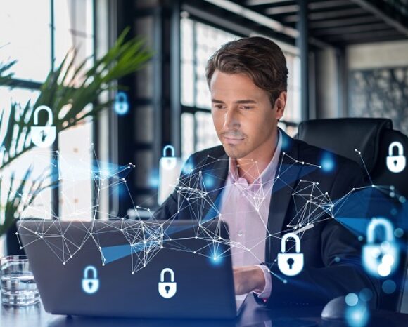 Ein Mann im Anzug sitzt an einem Schreibtisch und konzentriert sich auf seinen Laptop. Digitale Grafiken von Schlössern und Netzwerkverbindungen überlagern das Bild und symbolisieren Cybersicherheit. In diesem modernen Büro mit großen Fenstern und einer Fabrik ist klar: Alles im Lot: KMU sind mit ihrer Cybersicherheit zufrieden.