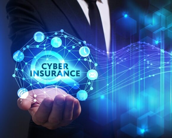 Ein Geschäftsmann im Anzug hält eine leuchtende Netzwerkkugel mit Symbolen für Technologie und Sicherheit. Der Text „Cyber Insurance“ steht im Mittelpunkt und spiegelt die Anforderungen wider, die Cyberversicherer heute an Unternehmen stellen. Er steht im Kontrast zu abstrakten digitalen Mustern und vermittelt ein futuristisches und sicheres Thema.