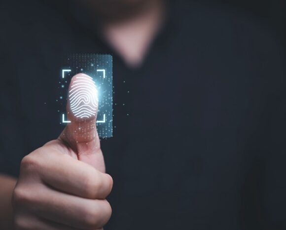 Eine Person hält ihren Daumen für einen Fingerabdruckscan hoch und erfasst so biometrische Daten im Rahmen der TeleTrusT-Initiative. Die leuchtende Oberfläche unterstreicht die Sicherheit im Einklang mit dem Ziel der erneuerten eIDAS-Verordnung, eine Grundlage für digitale Selbstbestimmung zu schaffen.