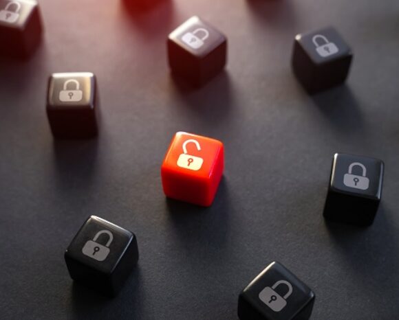 Eine rote Tastenkappe mit einem unverschlossenen Vorhängeschloss-Symbol sticht zwischen mehreren schwarzen Tastenkappen mit verschlossenen Symbolen hervor und erinnert an das erhebliche Gefahrenpotenzial einer kritischen Lücke im Microsoft Message Queuing Service – und das alles vor einem dunklen Hintergrund.