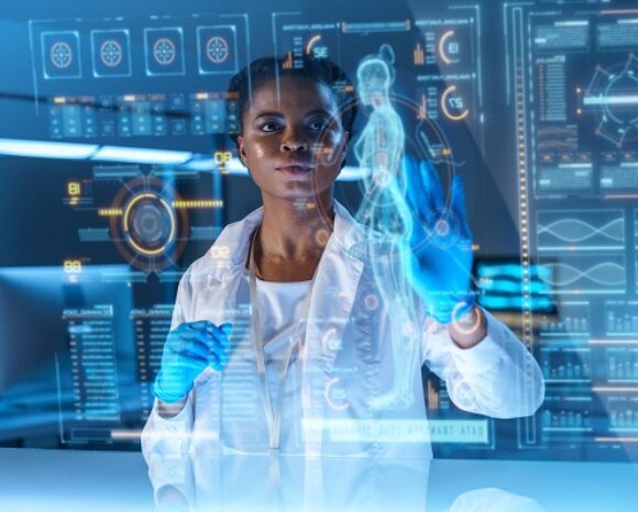 Ein Wissenschaftler im Laborkittel interagiert mit einer virtuellen holografischen Schnittstelle, die die menschliche Anatomie und verschiedene Datendiagramme anzeigt und so verdeutlicht, wie stark das Gesundheitswesen von Cybervorfällen betroffen ist. Die Szene wird von blauem Licht beleuchtet, was ihr eine futuristische Atmosphäre verleiht.