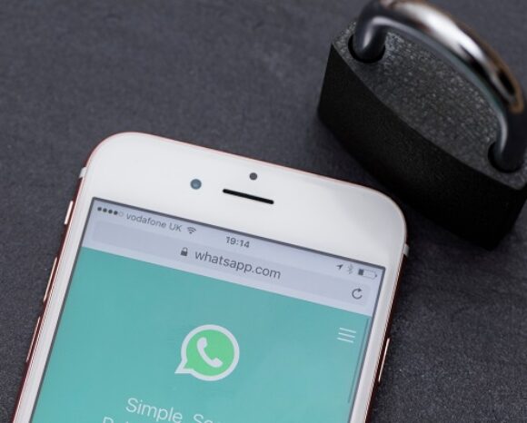 Vorhängeschloss neben geöffneter WhatsApp-Anwendung auf Smartphone