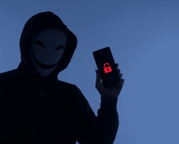 Anonymus Figur mit Smartphone und rotem Datenschutz-Symbol