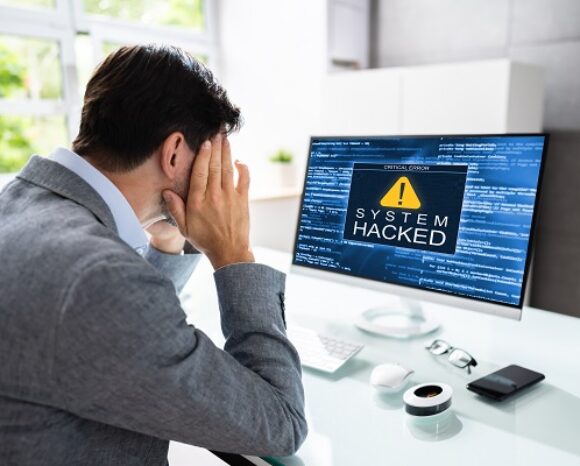 Mann vor gehacktem Rechner