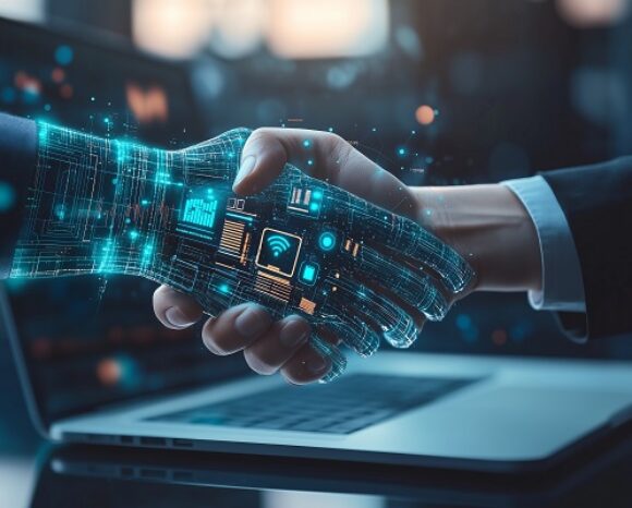 Eine menschliche Hand und eine digitale, holografische Hand mit Schaltkreismustern schütteln sich vor einem Laptop die Hände und symbolisieren die Partnerschaft zwischen Technologie und Mensch in der KI im Feld der praktischen Anwendung. Die Szene ist in blaues und orangefarbenes Licht getaucht und vermittelt ein futuristisches Thema.