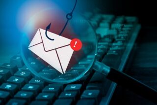 Mail unter Lupe vor Tastatur wird mit Haken gefischt