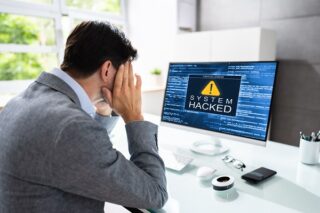 Mann vor dem Monitor des infizierten Rechners