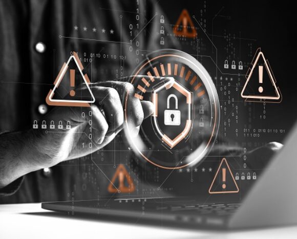 Hand tippt auf Laptop-Tastatur mit digitalen Symbolen im Vordergrund
