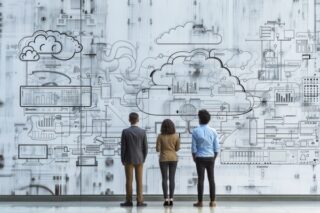 Drei Personen vor einem digitalen Schaubild