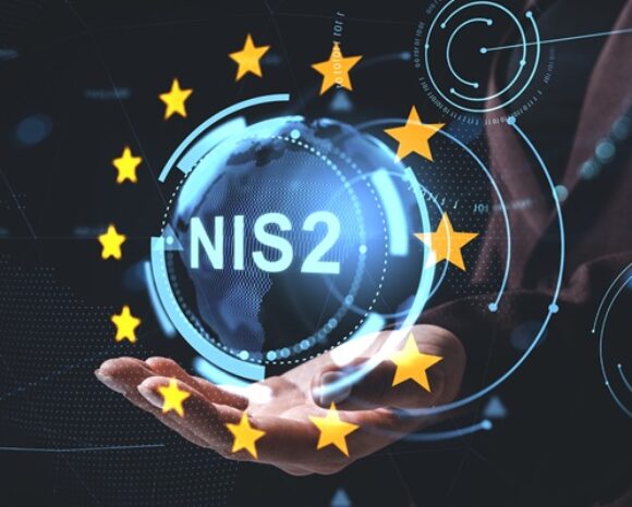 Digitales NIS2-Cybersicherheitskonzept mit holografischer Erde und EU-Sternen, die über einer Hand vor futuristischem Technologiehintergrund schweben.