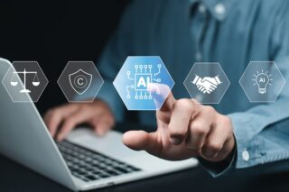 Menschliche Hand am Laptop tippt auf einen Button mit der Bedeutung KI-Projekte