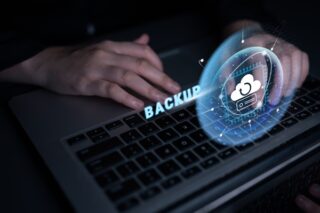 Hand an Tastatur, darüber Symbole für Backup