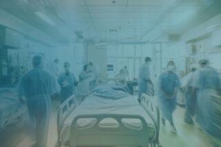 Krankenhauspersonal, das um ein Bett läuft.
