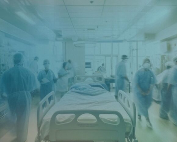 Krankenhauspersonal, das um ein Bett läuft.