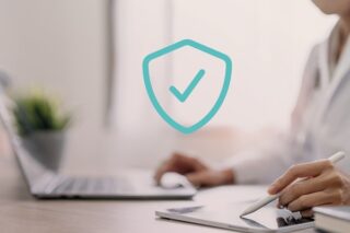 Frau arbeitet am Laptop. Datenschutzsymbol mit Häkchen