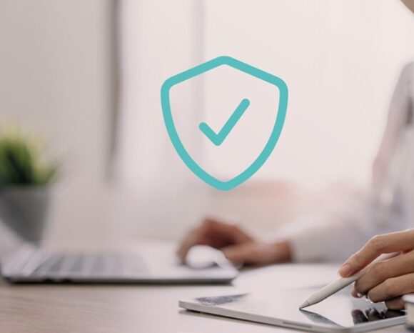 Frau arbeitet am Laptop. Datenschutzsymbol mit Häkchen
