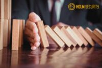 Hand stoppt fallende Domino-Steine