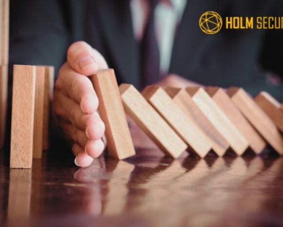Hand stoppt fallende Domino-Steine