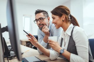 Mann und Frau vor Monitor