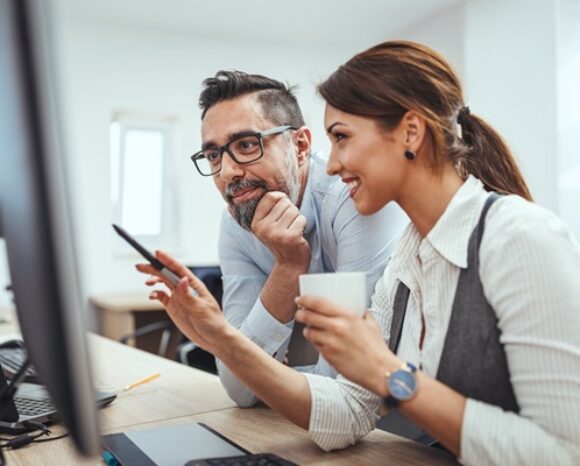 Mann und Frau vor Monitor
